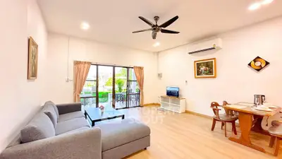 Spacious living room with modern decor and garden view, featuring a cozy sofa and dining area.