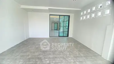 Spacious modern interior with tiled flooring and glass partition, ideal for versatile living space.