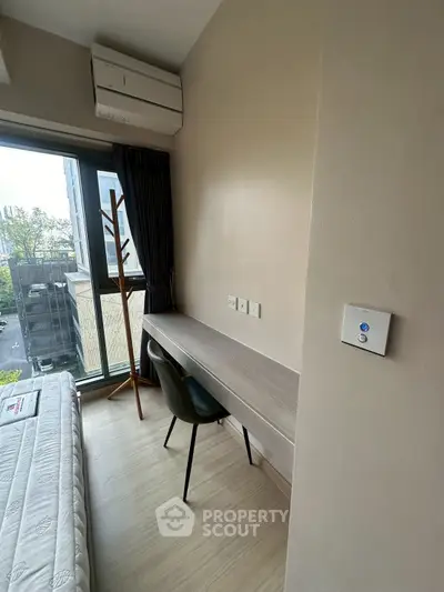 Modern bedroom with study area and large window offering city view