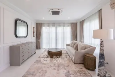 Elegant living room with modern decor, large windows, and stylish furniture
