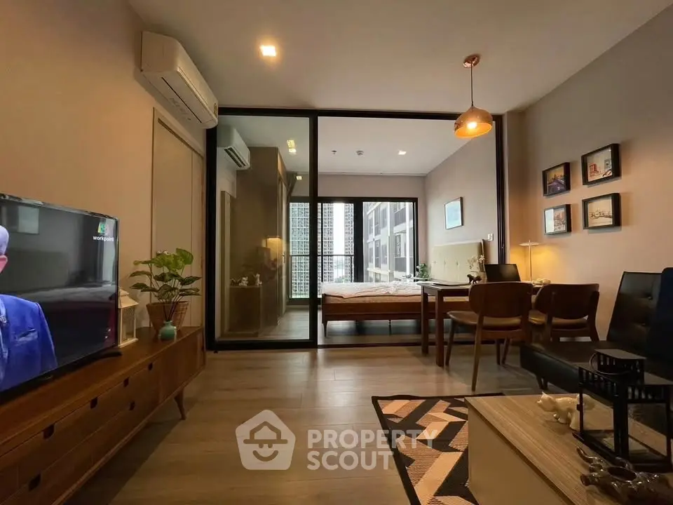 Modern living room with stylish decor and view into cozy bedroom