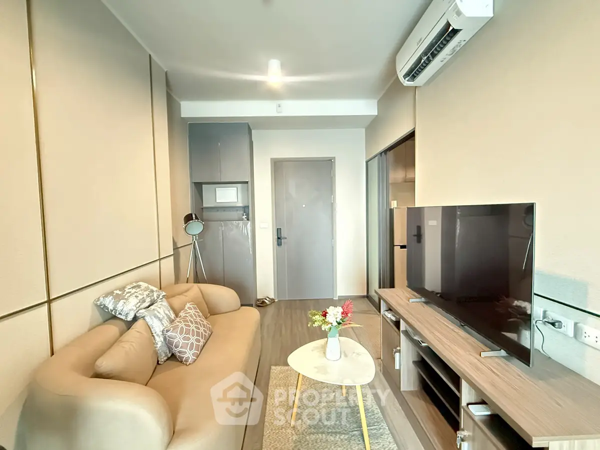 Modern living room with cozy sofa, flat-screen TV, and stylish decor in a contemporary apartment.