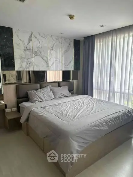 Luxurious bedroom with modern decor and large windows for natural light