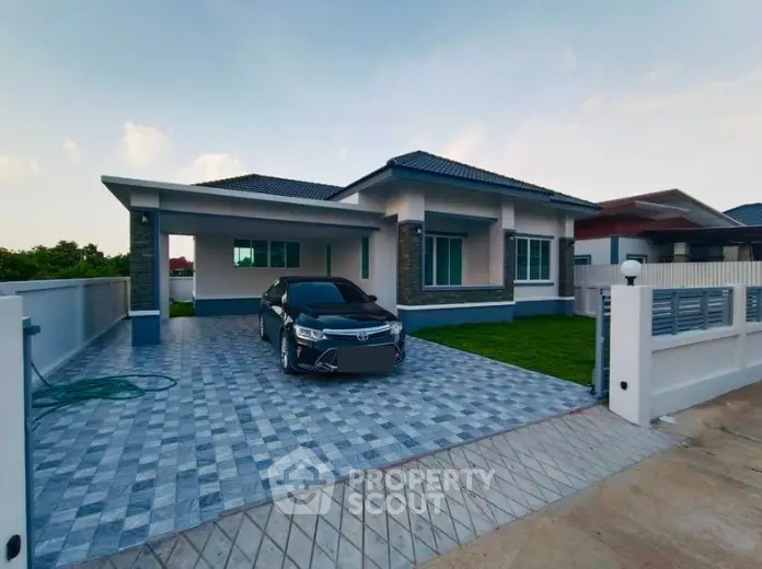Modern single-story house with spacious driveway and carport in a serene neighborhood.