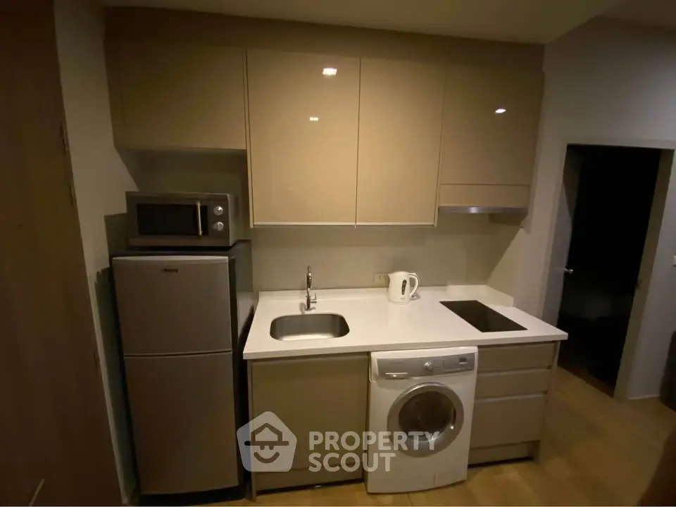 Modern compact kitchen with integrated appliances and sleek cabinetry