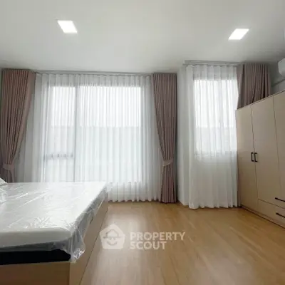 Spacious bedroom with large windows and modern furnishings