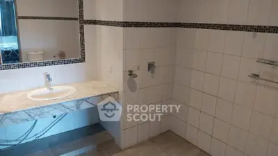 Spacious bathroom with elegant marble sink and modern tile design
