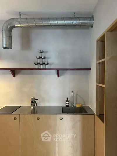 Modern minimalist kitchen with sleek wooden cabinets and industrial metal accents.