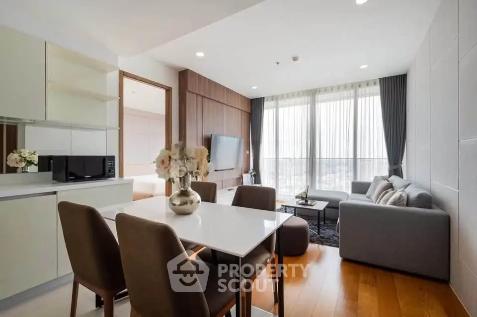 Modern living room with open kitchen, stylish decor, and natural light in a contemporary apartment.