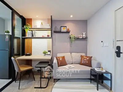 Modern living room with cozy sofa, stylish decor, and functional workspace in a compact apartment.