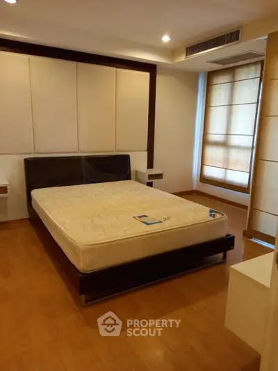 Spacious bedroom with modern design and large windows for natural light.