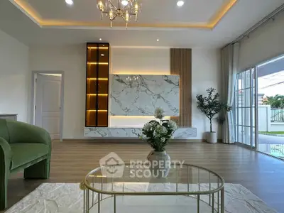 Luxurious living room with elegant marble feature wall and stylish decor, opening to a beautiful garden view.