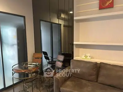 Modern living room with stylish furniture and glass table in a cozy apartment setting.