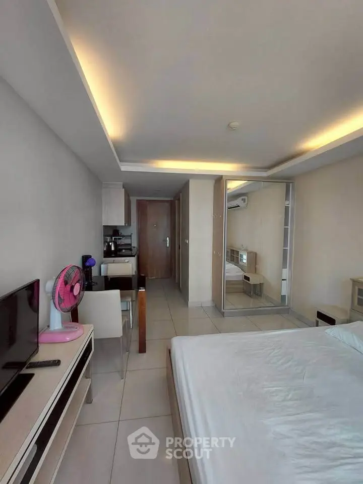 Modern bedroom with sleek furniture and mirrored wardrobe in a stylish apartment.