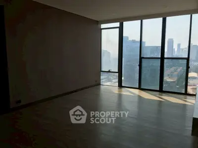 Spacious living room with floor-to-ceiling windows offering stunning city views.