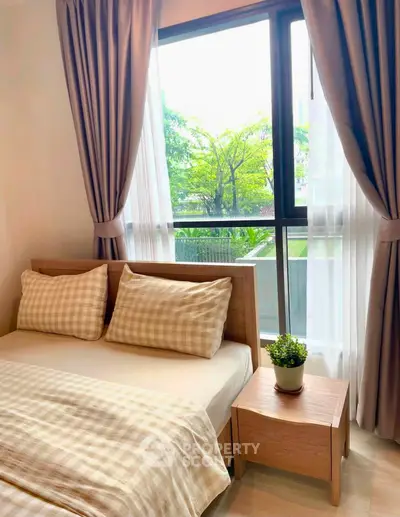 Cozy bedroom with large window and stylish decor in modern apartment