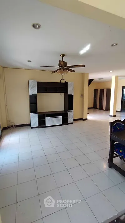 Spacious living room with ceiling fan and modern entertainment center