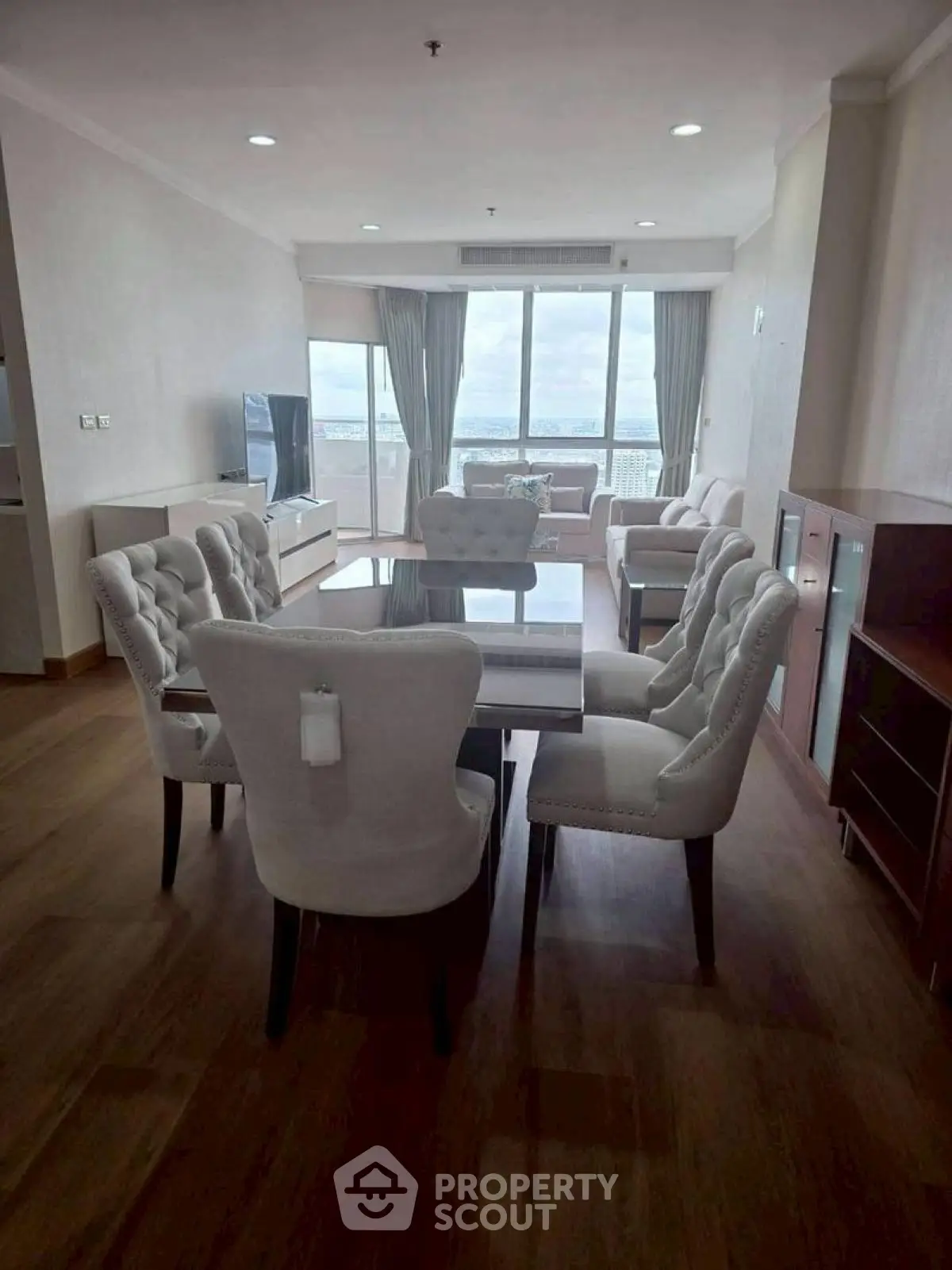 Spacious living room with elegant dining set and stunning city view