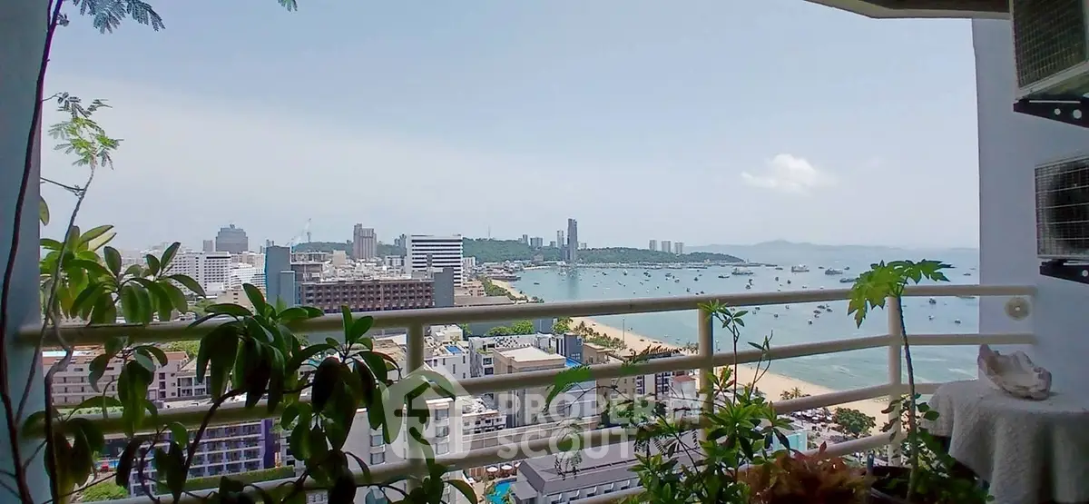 Stunning high-rise balcony view overlooking the ocean and cityscape, perfect for urban living.