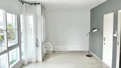 Spacious empty room with large windows and modern floor lamp