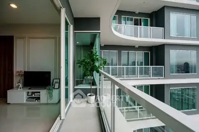 Modern apartment with spacious balcony and stunning city view, featuring sleek glass railings and contemporary design.