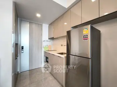 Modern kitchen with sleek cabinetry and stainless steel appliances in a contemporary apartment.