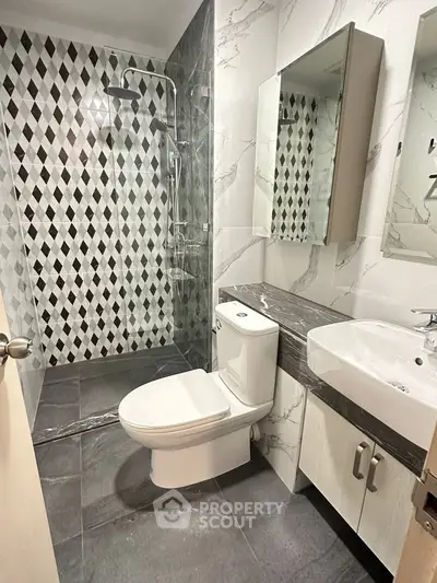 Modern bathroom with stylish black and white tile design and sleek fixtures.