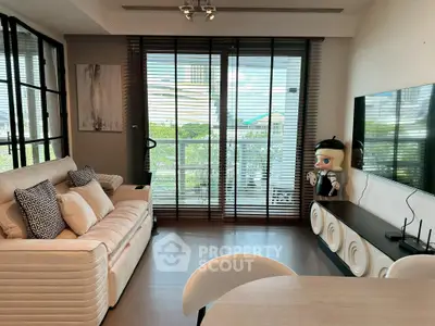 Modern living room with stylish decor and large windows offering a scenic view.