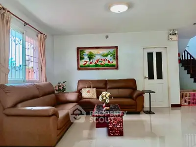 Spacious living room with elegant brown leather sofas and vibrant wall art