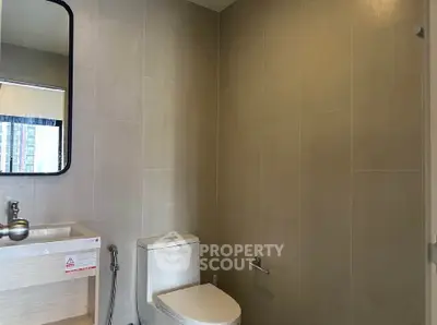 Modern bathroom with sleek fixtures and neutral tiles in a contemporary apartment.