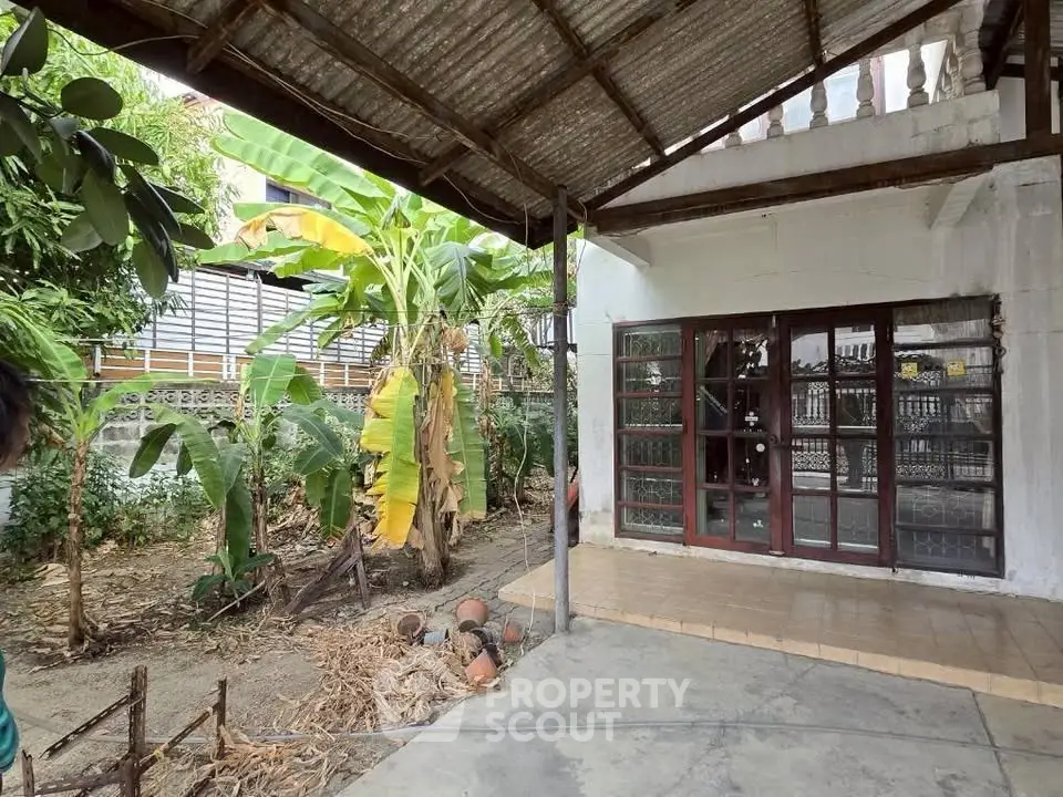 Charming outdoor garden area with lush greenery and rustic patio, perfect for relaxation and entertaining.