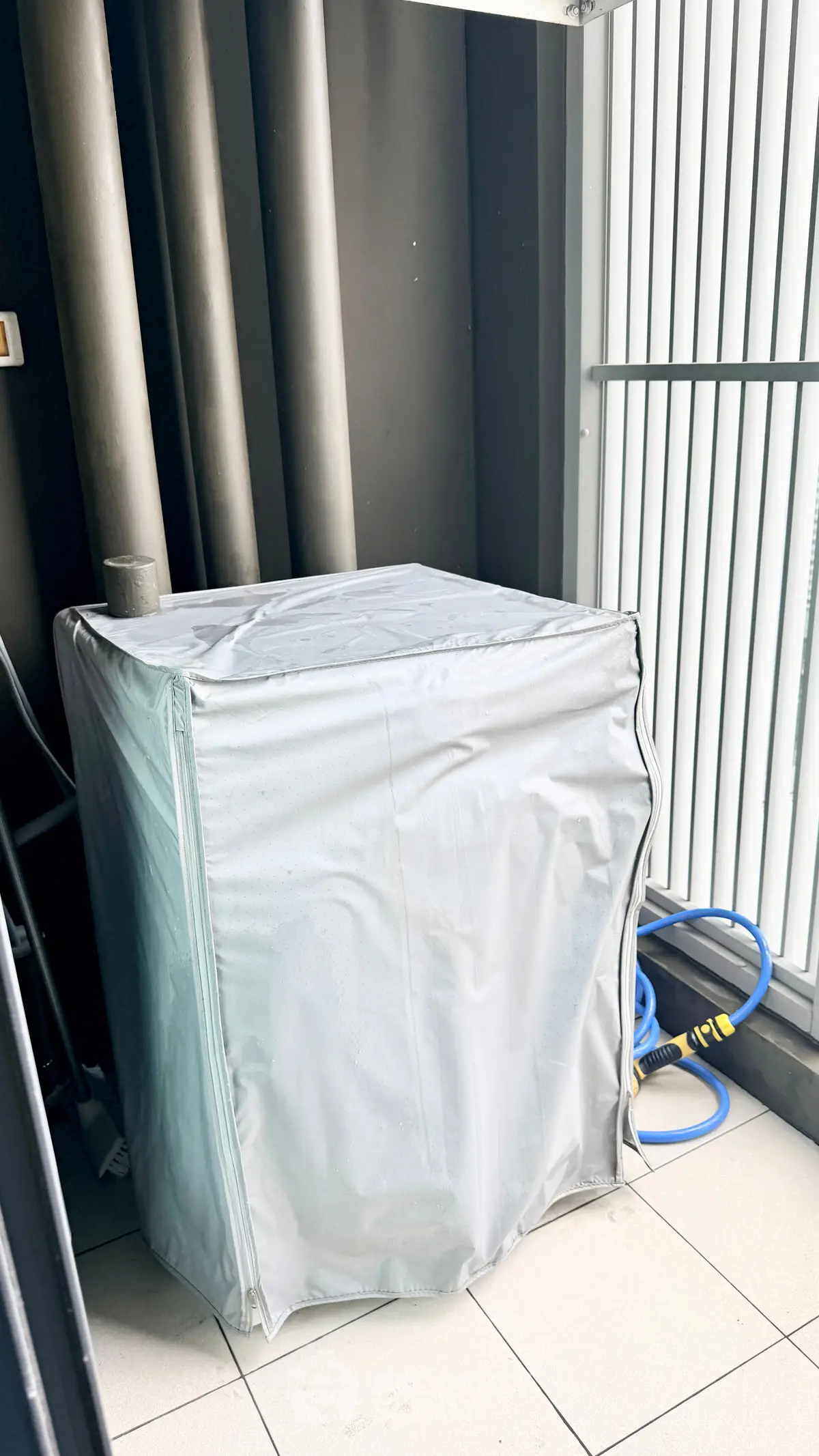 Outdoor balcony space with covered appliance and modern railing design.