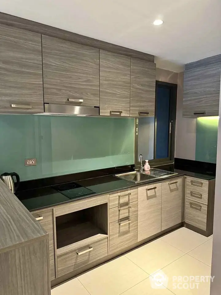 Modern kitchen with sleek cabinetry and glass backsplash