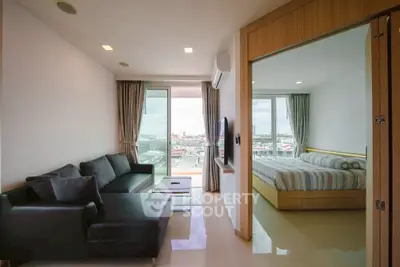 Modern condo with open living room and bedroom, featuring city view from balcony.