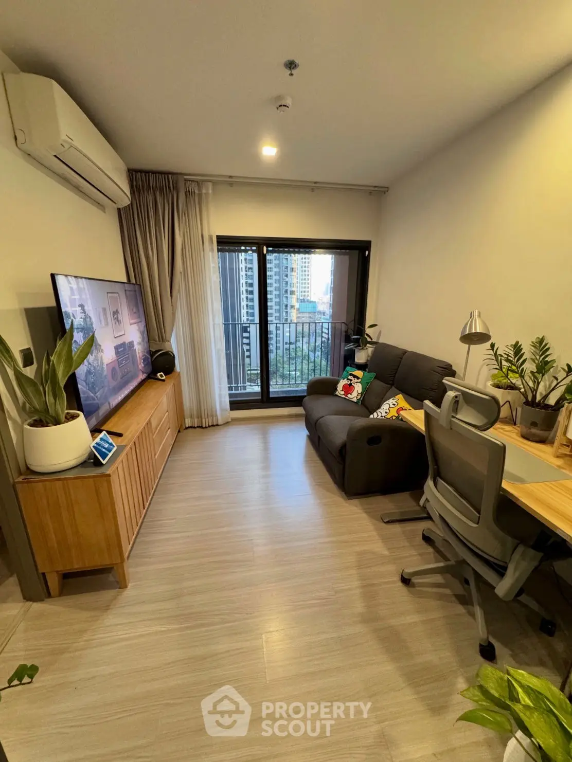 Modern living room with balcony view, stylish decor, and natural light.