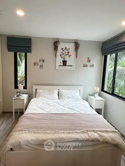 Cozy bedroom with large windows and stylish decor, perfect for relaxation.