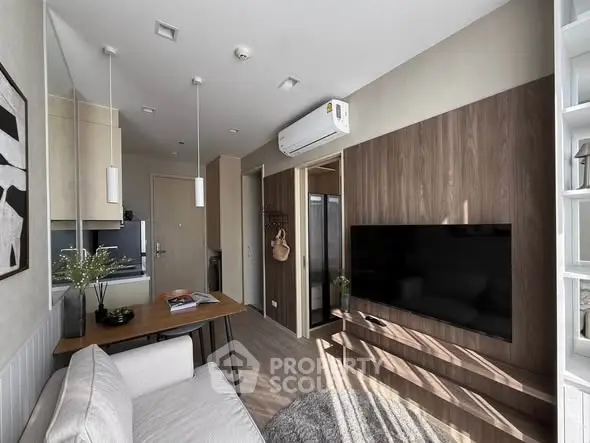 Modern living room with sleek design, featuring a wall-mounted TV and stylish furniture in a cozy apartment.