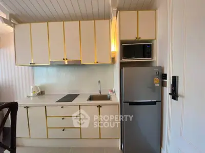 Modern kitchen with sleek cabinetry and stainless steel appliances in a stylish apartment.