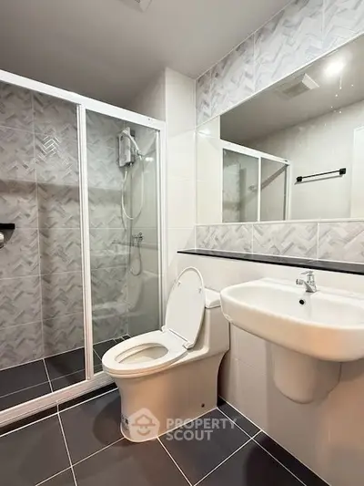 Modern bathroom with sleek shower and stylish tiles in contemporary apartment.