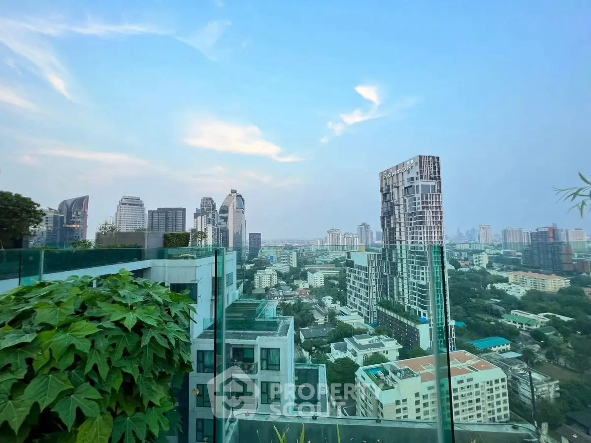 Stunning cityscape view from a modern rooftop terrace with lush greenery and glass railings.
