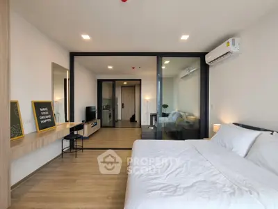 Modern bedroom with glass partition and stylish decor in a contemporary apartment.