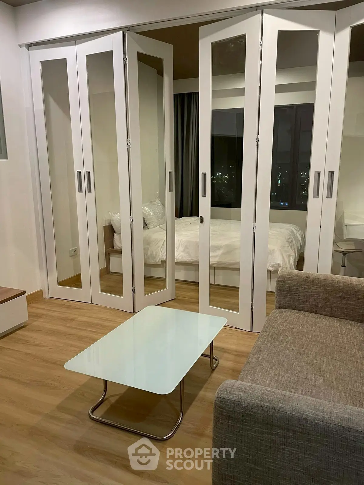 Modern studio apartment with glass partition and cozy living area