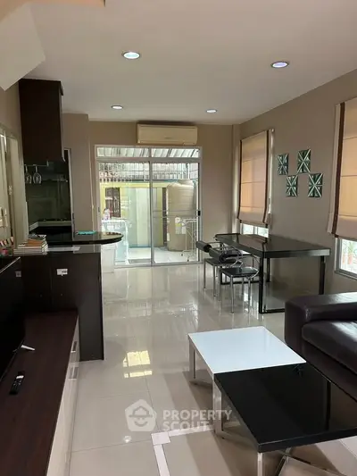 Modern living room with sleek furniture and large windows offering natural light.
