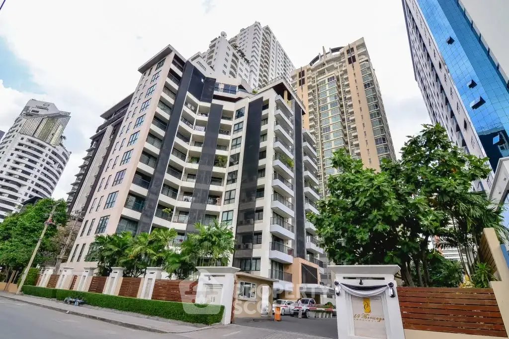 Modern high-rise condominium with lush greenery and urban skyline views.