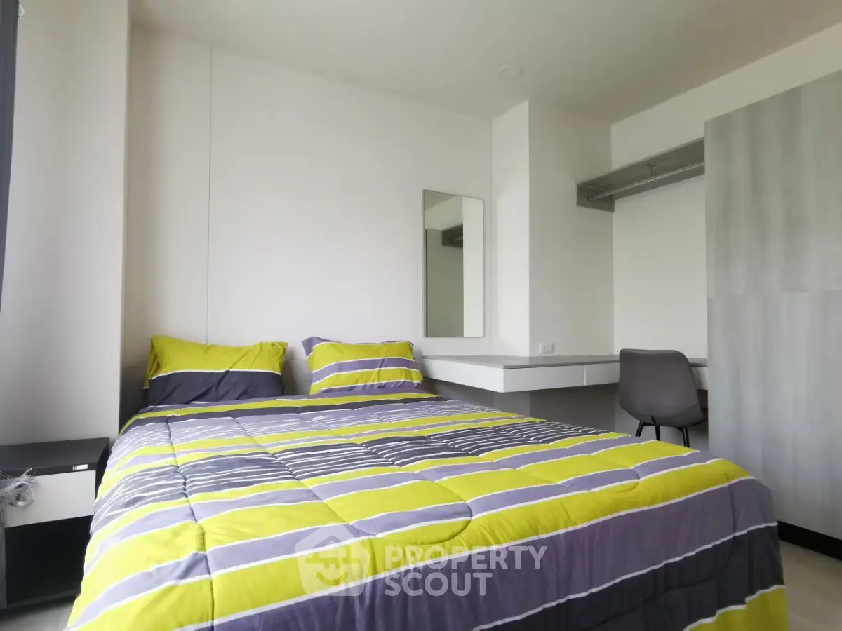 Modern bedroom with stylish decor and ample natural light, featuring a comfortable bed and sleek furnishings.