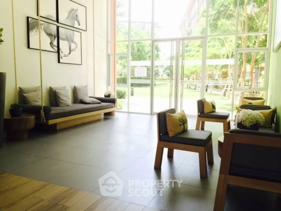 Modern living room with large windows and stylish furniture, offering a bright and inviting atmosphere.