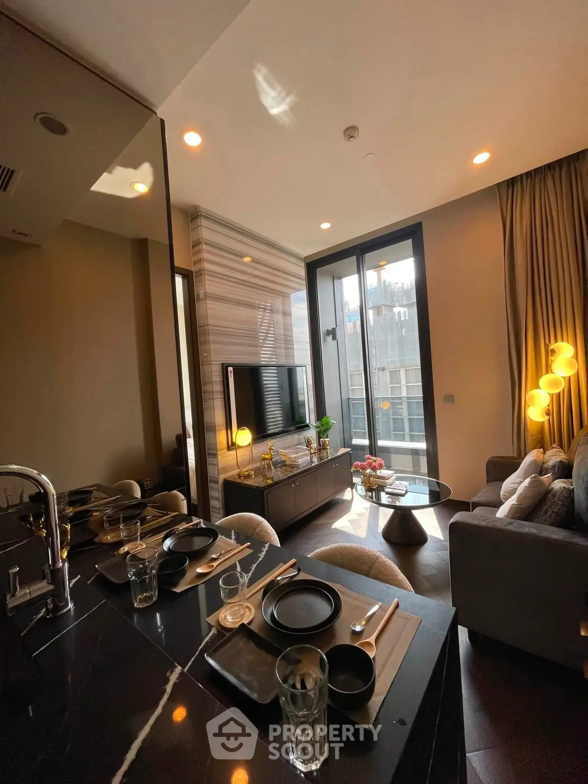 Modern living room with elegant decor and city view, featuring stylish furniture and ambient lighting.