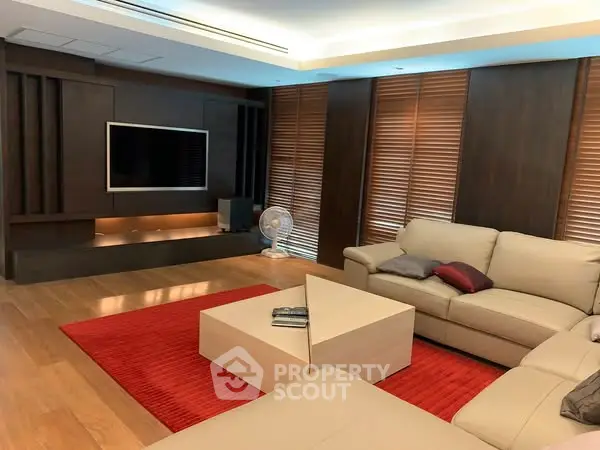 Luxurious living room with modern decor, leather sofas, and wooden accents.