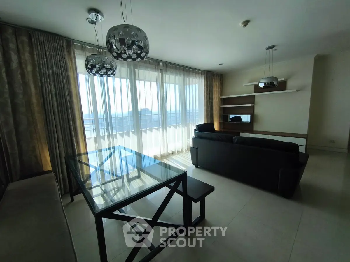 Spacious living room with modern furniture and large windows offering stunning views.