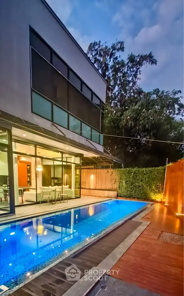 Luxurious modern home with stunning pool and elegant outdoor lighting, perfect for entertaining.